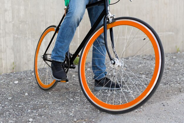 pessoas, viagens, turismo, transporte e estilo de vida - close-up do homem jovem hippie com bicicleta de marcha fixa na rua da cidade