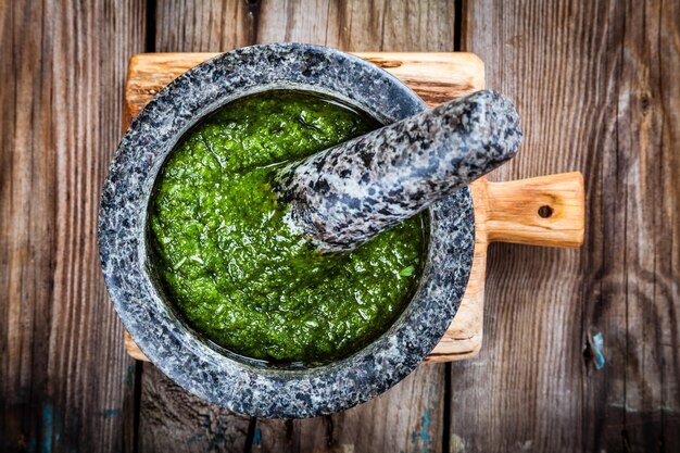 Pesto casero en un mortero sobre fondo de madera