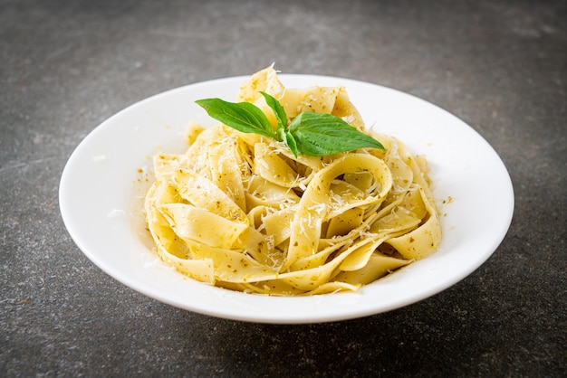 Pesto-Fettuccine-Nudeln mit Parmesan-Käse obenauf - italienische Küche