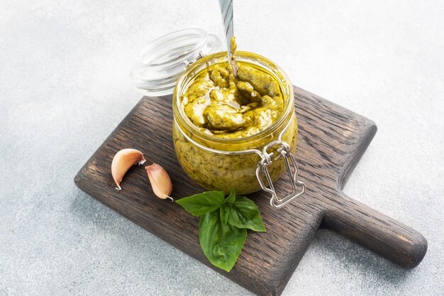 Pesto-Sauce im Glas, frische Basilikumblätter und Knoblauch. Platz kopieren