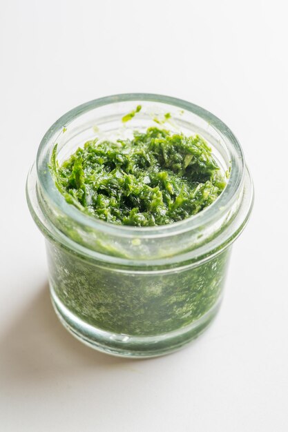 Pesto-Sauce in einem Glas auf weißem Hintergrund