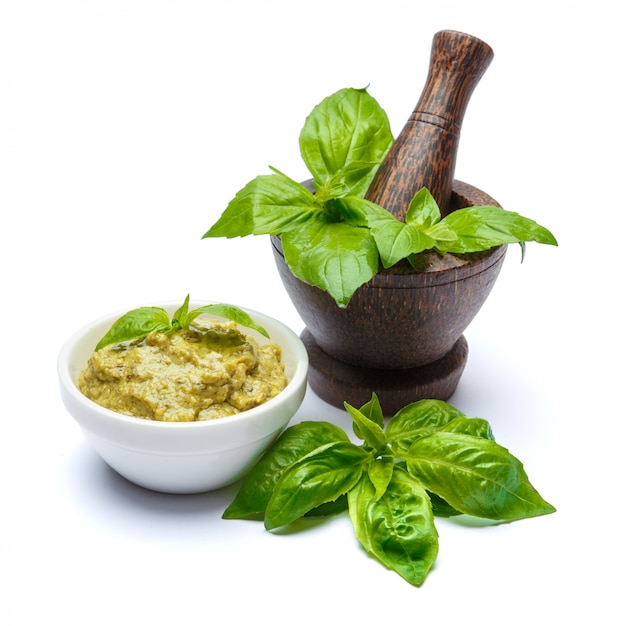 Pesto-Sauce mit frischen Basilikumblättern auf weißem Tisch