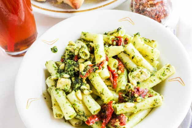 Pesto ziti com frango no prato em restaurante italiano.