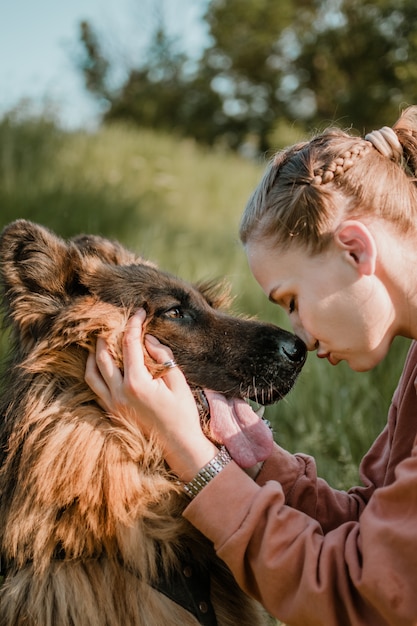 Pet Love. Jovem mulher muito feliz brinca com cão pastor alemão