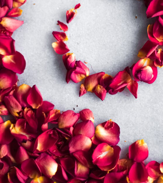 Pétalos de rosa sobre fondo de mármol decoración floral y boda flatlay tarjeta de felicitación de vacaciones telón de fondo para ...