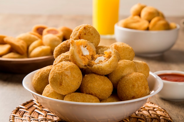 Foto petisco brasileiro. bolinho de frango com requeijão em fundo de madeira.