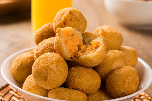 Foto petisco brasileiro. bolinho de frango com requeijão em fundo de madeira.