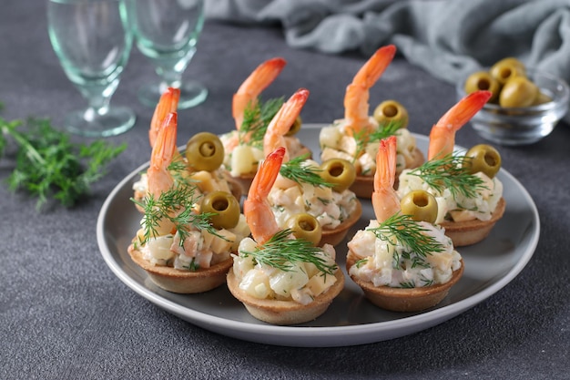 Petisco festivo de queijo de camarão e tortinhas de abacaxi em fundo cinza escuro