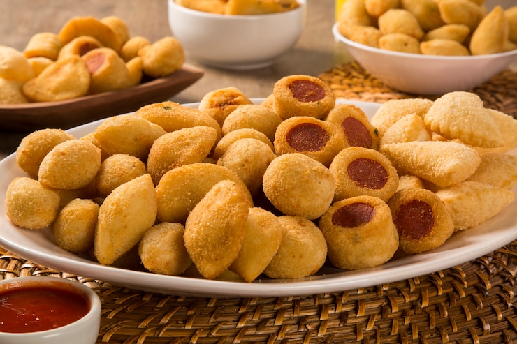 Foto petiscos brasileiros fritos em fundo de madeira.