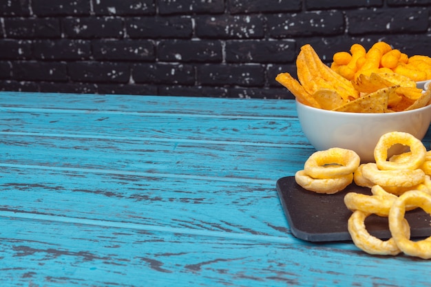 Petiscos de cerveja como biscoitos, batatas fritas, biscoitos em um fundo de superfície de madeira