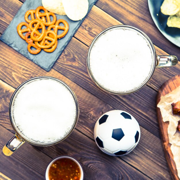 Petiscos e cervejas na mesa para a festa de futebol e assistir a partida de futebol.