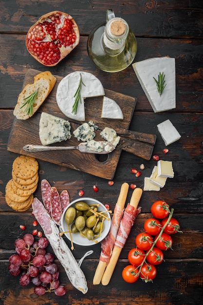 Petiscos espanhóis, queijo de carne, conjunto de ervas, mesa de madeira escura, postura plana