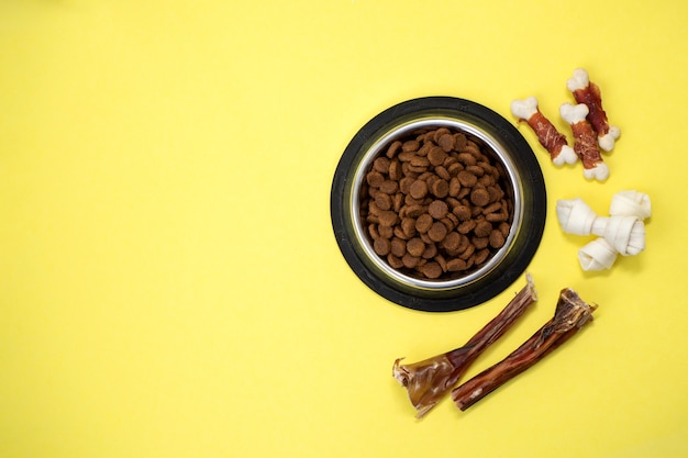 Petiscos para cães e ração seca em uma tigela com espaço de cópia