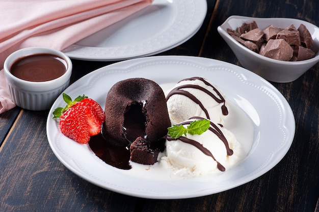 Petit Gateau con helado y fresa en la placa blanca.