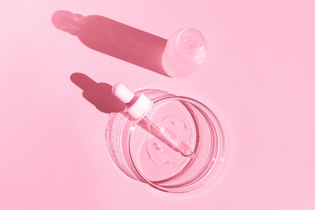 Petrischale Mit transparentem Gel Mit einer Pipette Kosmetikflasche Auf rosafarbenem Hintergrund