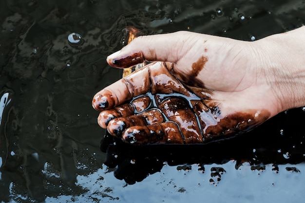 Foto petróleo crudo en la mano debido a la fuga de petróleo crudo. proceso de petróleo y gas