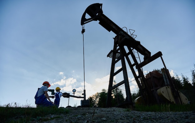 Foto un petrolero y un niño en uniforme de trabajo en una plataforma de perforación de petróleo