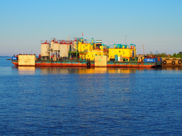 Petrosawodsk Russland 10. Juli 2021 Flussstation oder Seehafen Lager und Produktionsstätten Pier am Onegasee Karelien Autoreifen werden an den Seiten des Piers platziert Wasserhimmel und Horizont