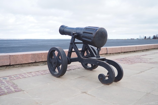 Foto petrozavodsk karelia rússia 18 de abril de 2024 terraplén do lago onega canhão decorativo de ferro fundido olhando para a água a capital da carélia era famosa por sua fundição de canhões alexandrovsky