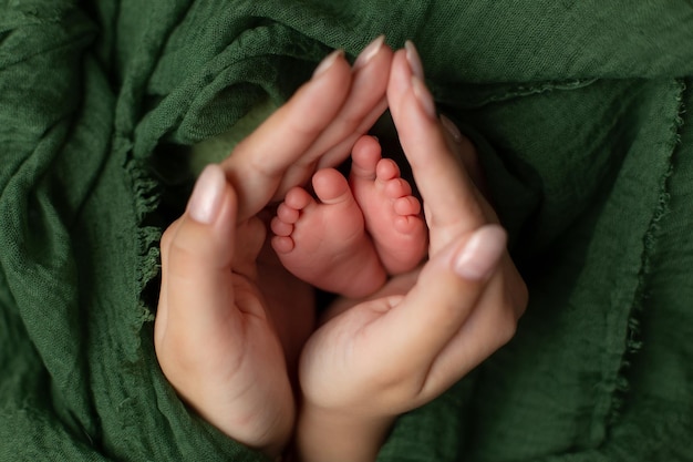 pezinhos de bebê nas mãos da mãe. recém-nascido. dedos dos pés