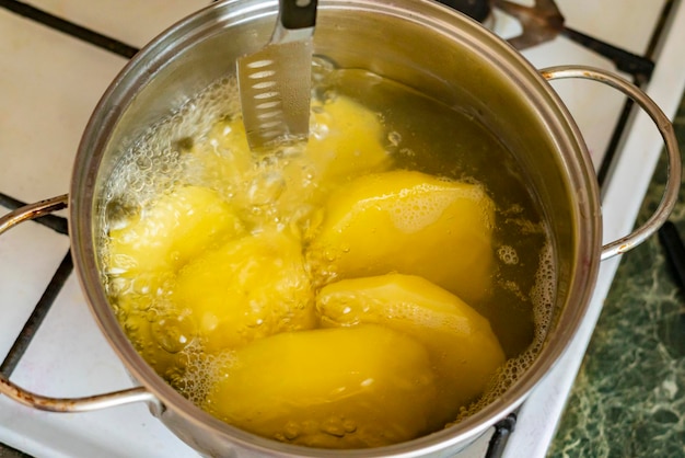 Pfanne mit kochender Kartoffel in der Küche b