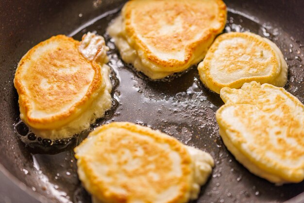 Pfannkuchen, die auf Bratpfanne mit Pflanzenöl braten