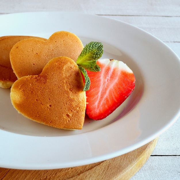 Pfannkuchen in Form eines Herzens mit Beeren.