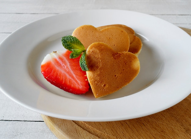 Pfannkuchen in Form eines Herzens mit Erdbeeren.