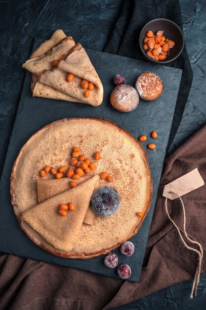 Pfannkuchen m gefrorene Beeren auf einem dunklen Hintergrund.