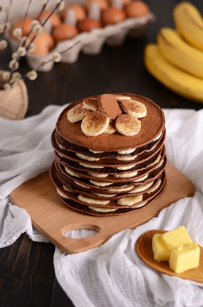 Pfannkuchen mit Bananen-, Walnuss- und Ahornsirup zum ein Frühstück auf hölzerner Hintergrundnahaufnahme.