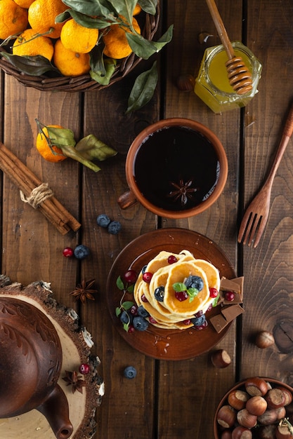 Pfannkuchen mit Beeren sind gestapelt Ein Tisch mit Pfannkuchen und Tee an der Spitze