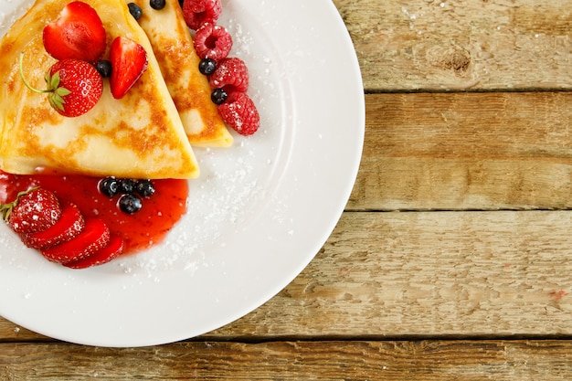 Pfannkuchen mit Beeren und Zuckerpulver