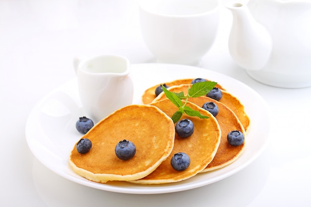 Pfannkuchen mit Beerenblaubeeren in einer Platte auf einem weißen Hintergrund