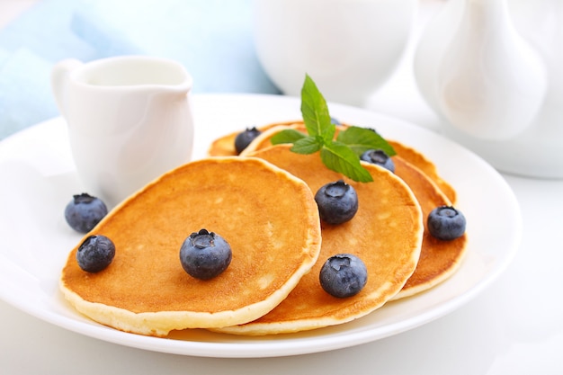 Pfannkuchen mit Beerenblaubeeren in einer Platte auf einem weißen Hintergrund