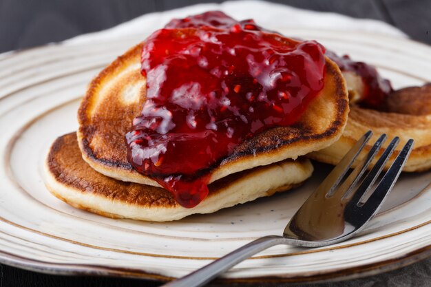 Pfannkuchen mit Beerenmarmelade auf Küchentischhintergrund