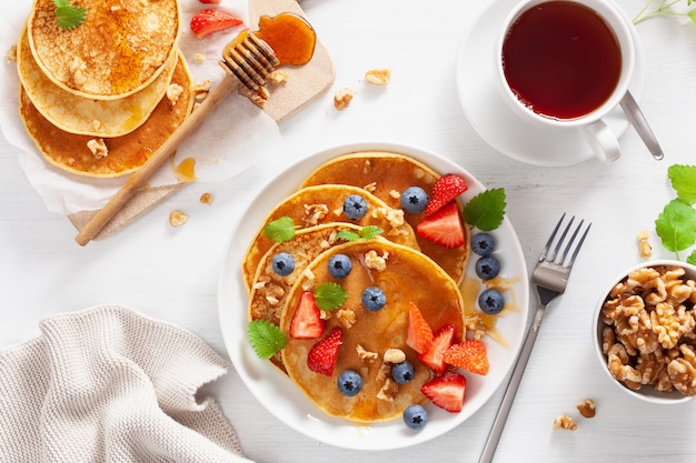 Pfannkuchen mit Blaubeer-Erdbeer-Honig und Nüssen zum Frühstück