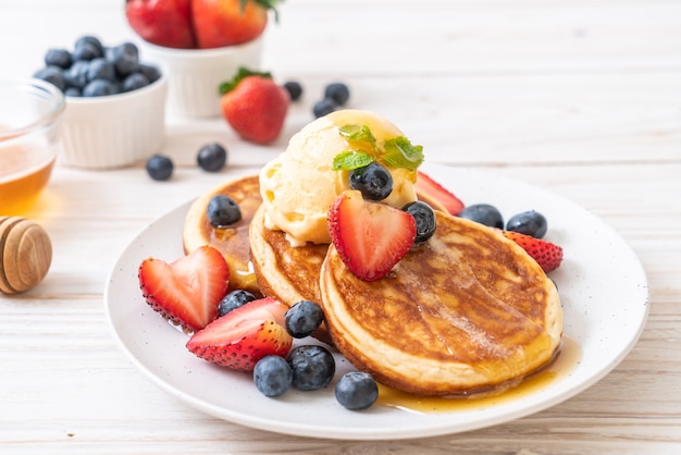 Pfannkuchen mit Blaubeeren, Erdbeeren, Honig und Vanilleeis