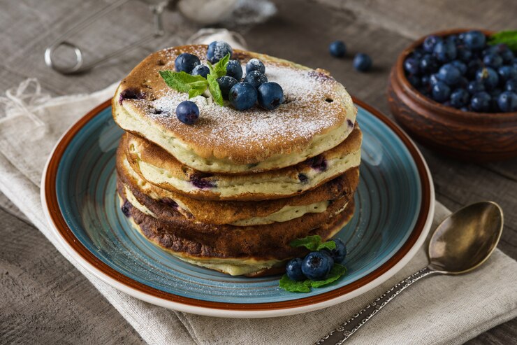Pfannkuchen mit Blaubeeren, Minze und Puderzucker.