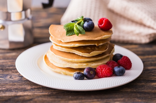 Pfannkuchen mit Blaubeeren und Himbeeren auf einem Teller