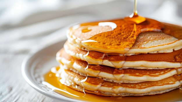 Pfannkuchen mit Butter und Honigsirup auf dem weißen Teller, das auf einem weißen Hintergrund isoliert ist