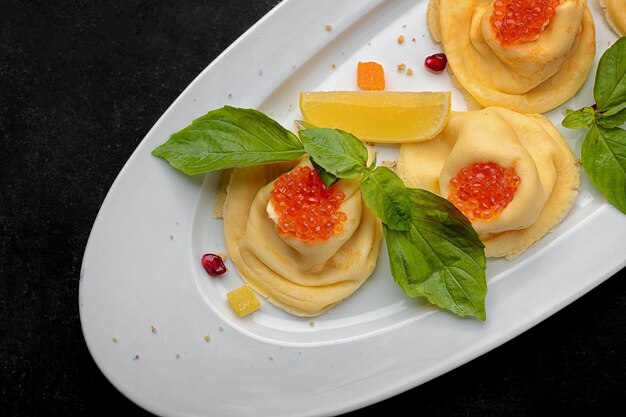 Pfannkuchen mit dunklem Hintergrund des roten Kaviarbasilikums