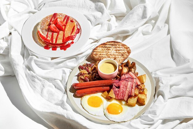 Pfannkuchen mit englischem Frühstück auf einem weißen Blatt Starkes Licht