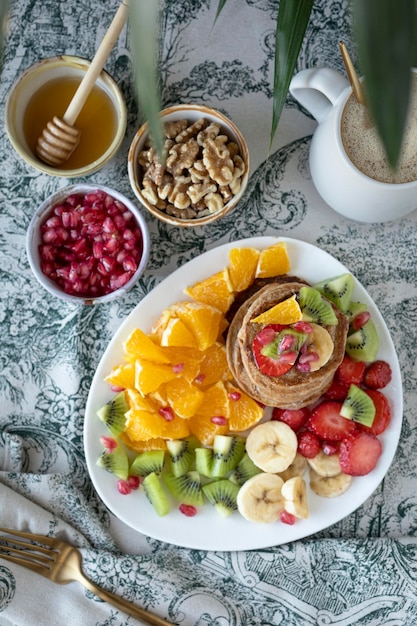 Pfannkuchen mit frischem Obst. Obstsalat mit glutenfreien Pfannkuchen. Gesundes Frühstück voller Vitamine