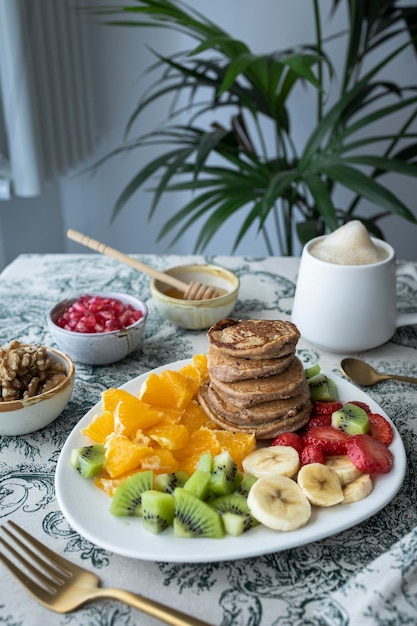 Pfannkuchen mit frischem Obst. Obstsalat mit glutenfreien Pfannkuchen. Gesundes Frühstück voller Vitamine