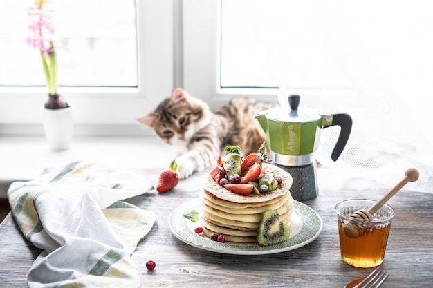 Pfannkuchen mit frischen Beeren und Honig und Tee