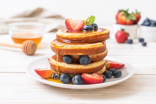 Pfannkuchen mit frischen Blaubeeren, frischen Erdbeeren und Honig