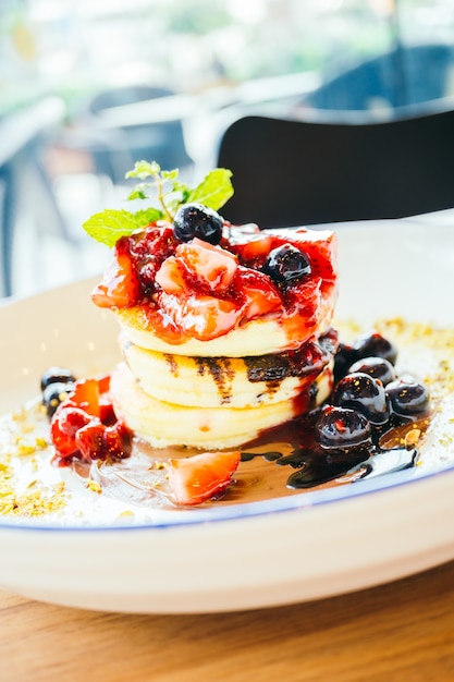 Pfannkuchen mit gemischten Beerenfrüchten im weißen Teller