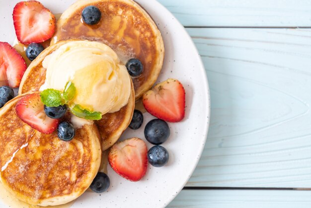 Pfannkuchen mit Heidelbeeren, Erdbeeren, Honig und Vanilleeis