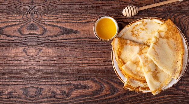 Pfannkuchen mit Honig auf einem Teller. Draufsicht,