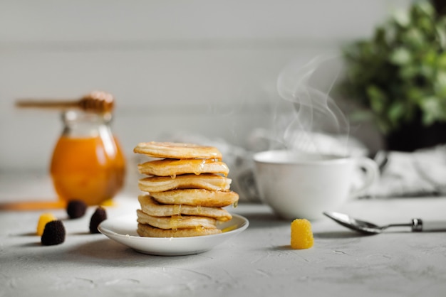 Pfannkuchen mit Honig und einer Tasse Tee